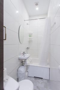 een witte badkamer met een toilet en een wastafel bij New studio near metro Pushkinska, Universytet - Chernyshevska str. 95-1 in Charkov