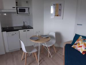 una pequeña cocina con mesa y sillas en una habitación en LE COCOON DE SAINT JEAN PROCHE CLINIQUE DE L UNION, en Saint-Jean