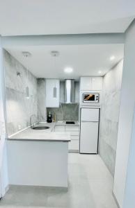 ベナルマデナにあるBenal Beach Sea View Apartment (Benalmadena)の白いキッチン(シンク、食器洗い機付)