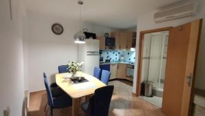 a kitchen and dining room with a table and blue chairs at Tartini Square House FERGO in Piran