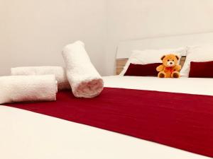 um urso de peluche sentado em cima de duas camas em Joy City Stay Paris 5&6 em Timisoara