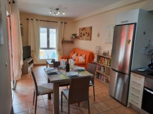 a kitchen and dining room with a table and a refrigerator at Corralejo Happy in Corralejo
