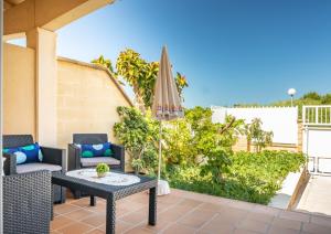 une terrasse avec une table et un parasol dans l'établissement Estrella Verde, à Alcúdia