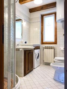 a bathroom with a washing machine and a toilet at Betulla House - AffittiPontediLegno in Ponte di Legno +8 photos