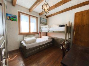 a room with two bunk beds and a table at Betulla House - AffittiPontediLegno in Ponte di Legno
