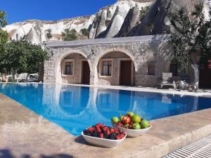 a resort with two bowls of fruit next to a swimming pool at Seven Rock Cave Hotel in Goreme