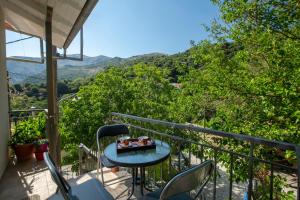 a table and chairs on a balcony with a view at Konstantino's House in Áyios Ilías