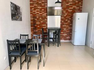 ein Esszimmer mit einem Tisch und Stühlen sowie einem Kühlschrank in der Unterkunft O'Key Home in Rostow am Don