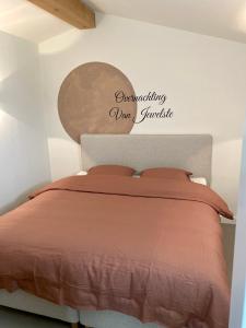 a bedroom with a bed with a sign on the wall at Overnachting Vanjewelste in Enschede