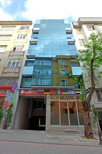 un edificio alto con un árbol delante de él en The Marist Hotel Kadikoy, en Estambul