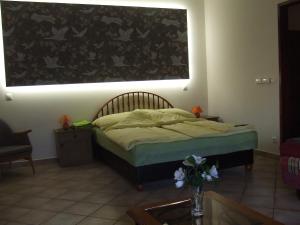 a bedroom with a bed with a large picture on the wall at Welcome Apartman in Hajdúszoboszló
