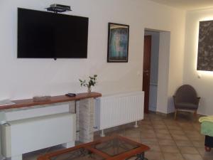 a living room with a flat screen tv on the wall at Welcome Apartman in Hajdúszoboszló