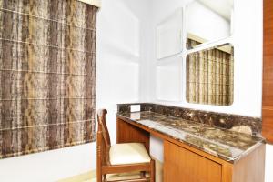 a bathroom with a sink and a chair at Hotel Vacation Inn in Amritsar +80 photos