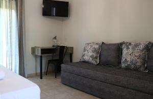a living room with a couch and a desk at Aliston Hotel Thassos in Skala Potamias