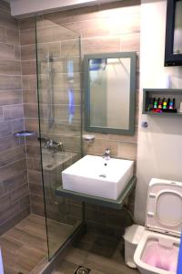 a bathroom with a sink and a glass shower at Aliston Hotel Thassos in Skala Potamias