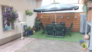 a patio with a table and chairs and an umbrella at Ferienwohnung Döring in Erfurt