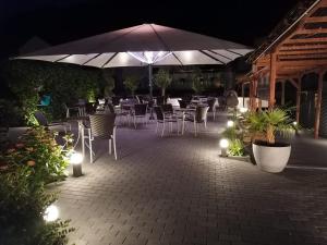 Moselromantik Hotel Am Panoramabogen في كوشيم: فناء به طاولات وكراسي ومظلة