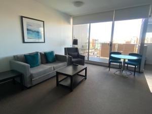 
a living room filled with furniture and a window at Honeysuckle Executive Apartments in Newcastle

