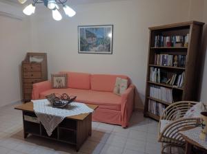 a living room with a pink couch and a book shelf at Magdalena & Bambino apartments in Sarti