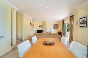 a dining room with a wooden table and white chairs at Vale de Lobo by Intiholidays in Vale do Lobo