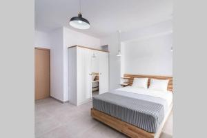 een slaapkamer met een bed en een witte muur bij Maisonnette Giannis in Pitsidia
