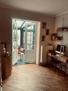 a room with a door and a table and a desk at B&B Marie-J of Bruges in Bruges