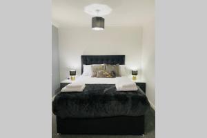 um quarto com uma cama grande e uma cabeceira preta em "Fishermans House" By Greenstay Serviced Accommodation - Large 4 Bed House With Parking - The Perfect Choice For Contractors, Families & Mixed Groups em Grimsby