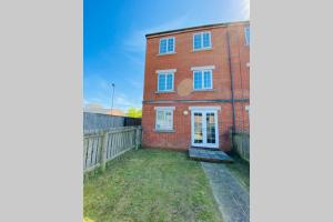 uma casa de tijolos com uma cerca em frente em "Fishermans House" By Greenstay Serviced Accommodation - Large 4 Bed House With Parking - The Perfect Choice For Contractors, Families & Mixed Groups em Grimsby
