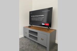 a flat screen tv sitting on top of a cabinet at "Fishermans House" By Greenstay Serviced Accommodation - Large 4 Bed House With Parking - The Perfect Choice For Contractors, Families & Mixed Groups in Grimsby