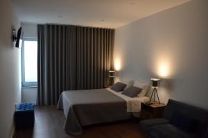 um quarto de hotel com uma cama e um sofá em JM Stay em Aveiro