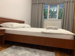 1 cama grande en un dormitorio con ventana en EUNICE apartament, en Oradea