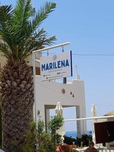 a sign for a marfila hotel next to a palm tree at Marilena in Skala Eresou