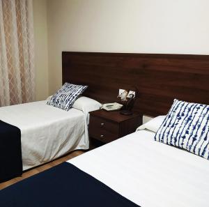 a bedroom with two beds and a phone on a night stand at Hosteria de Rafi in Priego de Córdoba