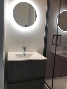 uma casa de banho com um lavatório e um espelho em Work or holiday nieuw studio Santhooft em Nieuwpoort