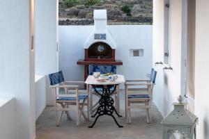 a table and chairs in a room with a stove at Le Grand Blue Villa in Akrotiri