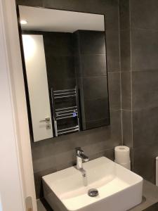 y baño con lavabo blanco y espejo. en Sunny new lovely apartment 60 meters from the metro en Atenas