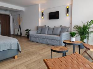 a living room with a couch and two tables at Sunny new lovely apartment 60 meters from the metro in Athens
