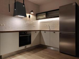 una cucina con armadi bianchi e frigorifero in acciaio inossidabile di Sunny new lovely apartment 60 meters from the metro ad Atene