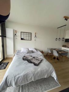 een slaapkamer met een groot bed en een tafel bij Work or holiday nieuw studio Santhooft in Nieuwpoort