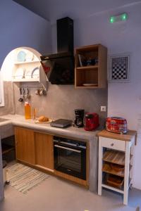a kitchen with a counter with a stove top oven at Le Grand Blue Villa in Akrotiri