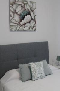 Girassol Alojamento Local في مونتمور - أو - نوفو: غرفة نوم بسرير مع لوحة على الحائط