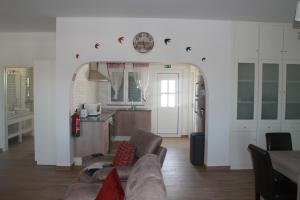 a living room with a couch and a kitchen at Girassol Alojamento Local in Montemor-o-Novo