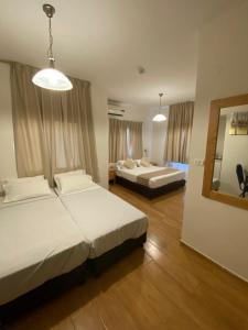 a hotel room with two beds and a mirror at Berger Hotel in Tiberias