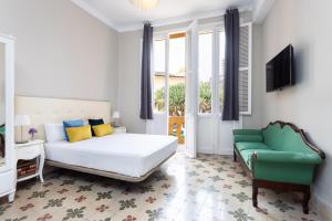 1 dormitorio con 1 cama y 1 sofá verde en Central Lofts, en Santa Cruz de Tenerife