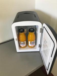 an open refrigerator with two jars of orange juice at The Coach and Horses in Parkham