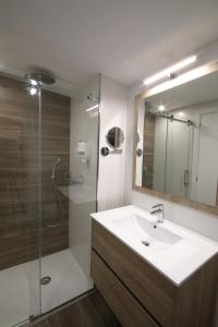 a bathroom with a sink and a shower with a mirror at A Verdella Villas in Sanxenxo