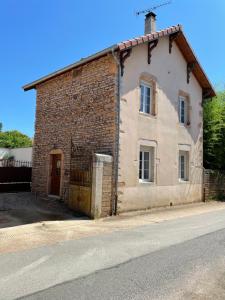 an old brick building on the side of a street at Gîte de la Grenouillette in Saint-Maurice-de-Satonnay