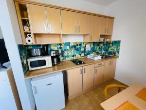 a small kitchen with a sink and a microwave at Joy Apartman in Zalakaros