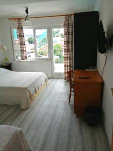 um quarto com uma cama, uma secretária e uma janela em Rooms Izola em Izola