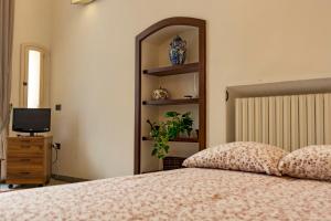ナポリにあるSuite Filangieriのベッドルーム(鏡付きベッド1台、テレビ付)